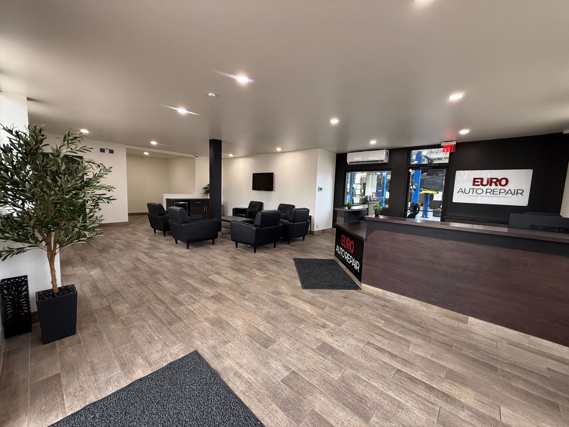 Interior of Euro Auto Repair waiting area; wood floors, black chairs, and a reception desk | Euro Auto Repair