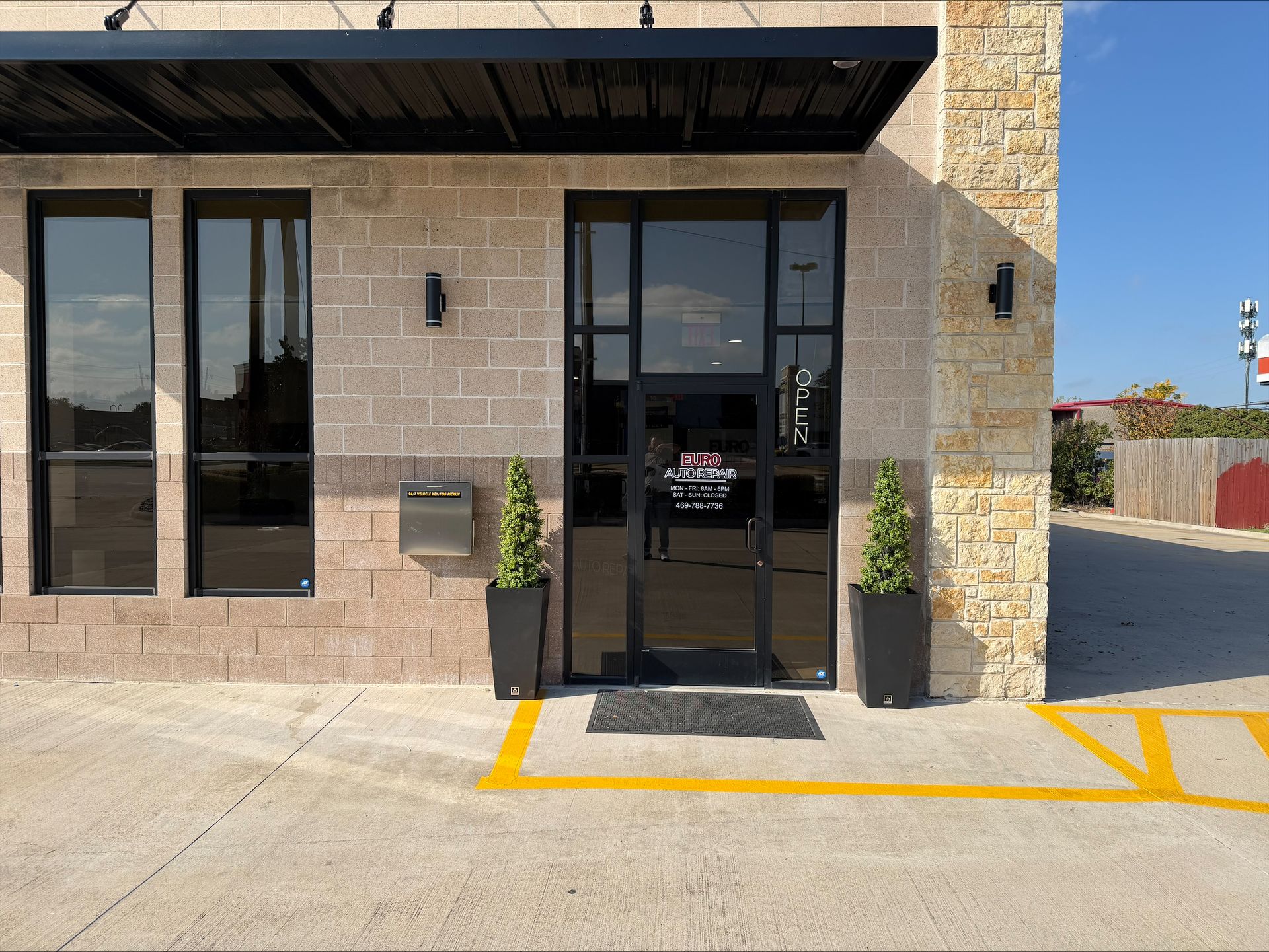 Exterior of building with a black awning and door.  | Euro Auto Repair