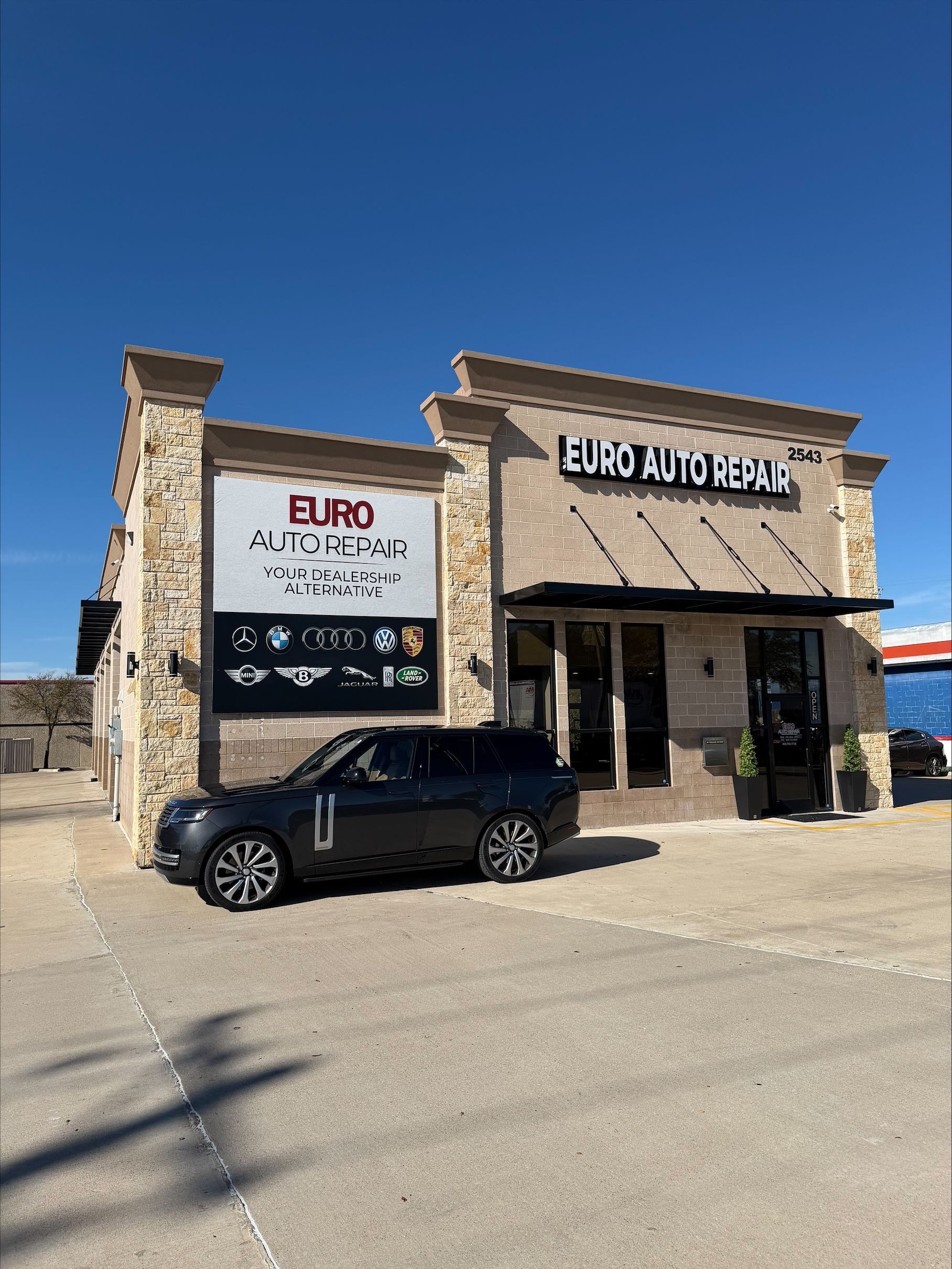 Black SUV parked outside Euro Auto Repair shop with signage | Euro Auto Repair
