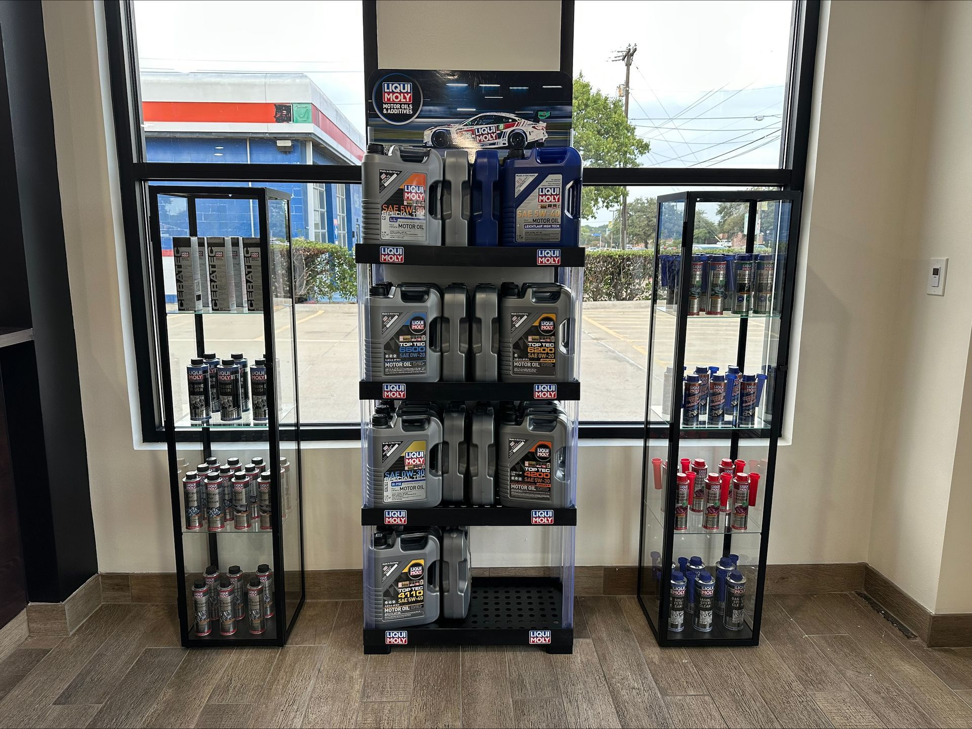 Oil bottles displayed on shelves inside a store, with a window and outdoor view | Euro Auto Repair
