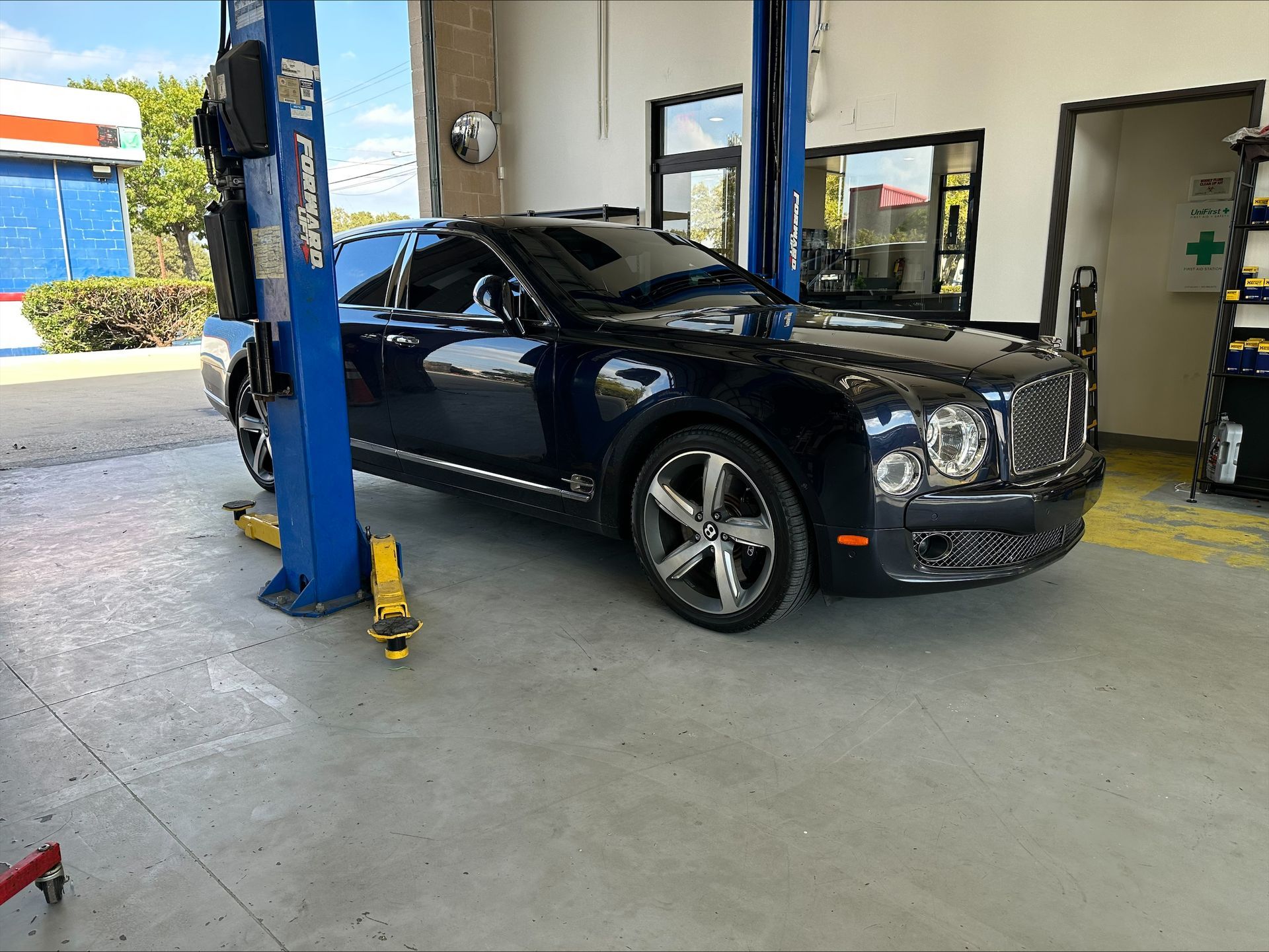 Dark blue Bentley sedan on a car lift in a repair shop | Euro Auto Repair