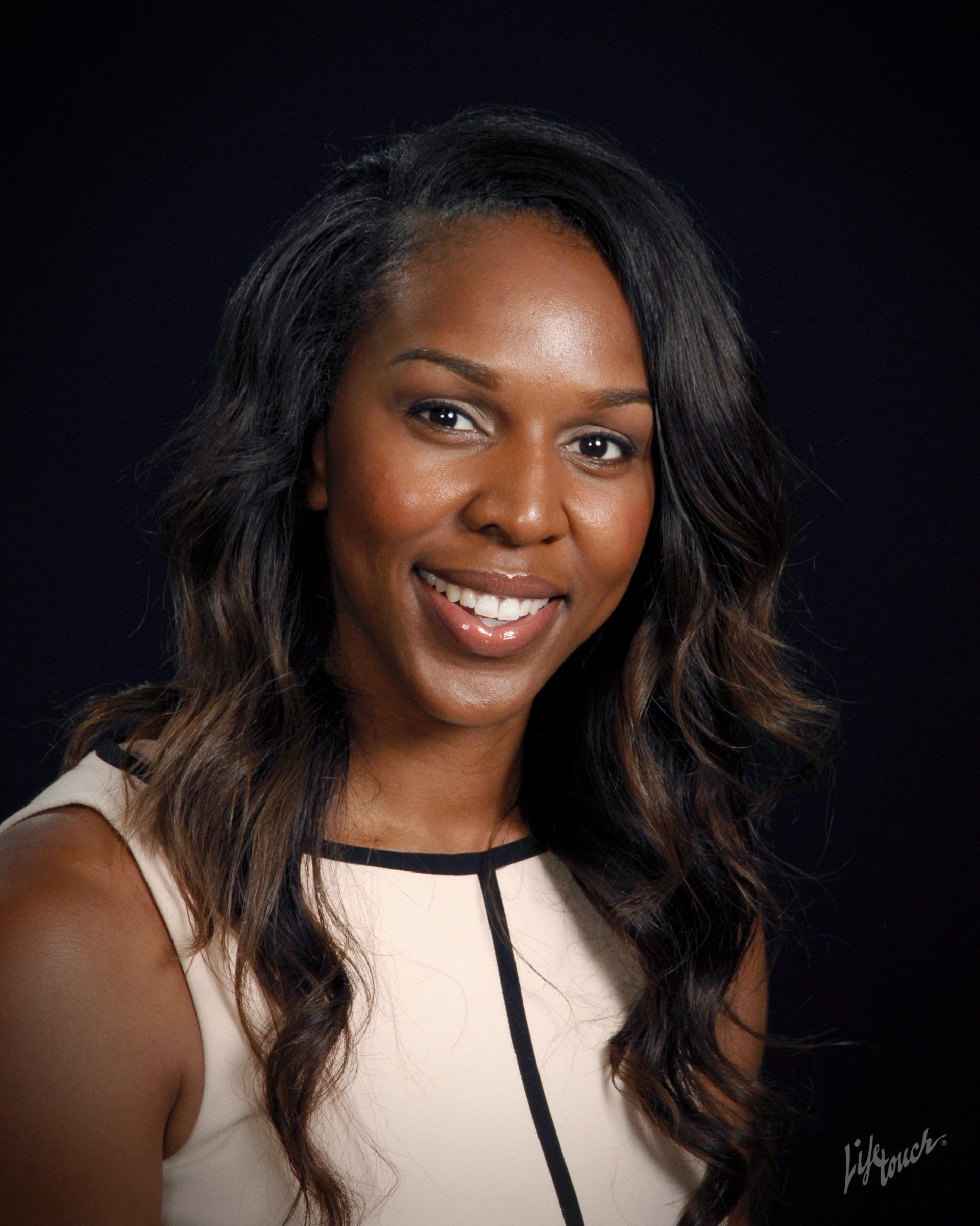 A woman with long hair is smiling for the camera.