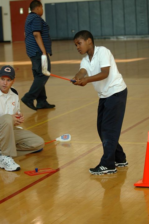 A boy wearing a white shirt with the letter q on it