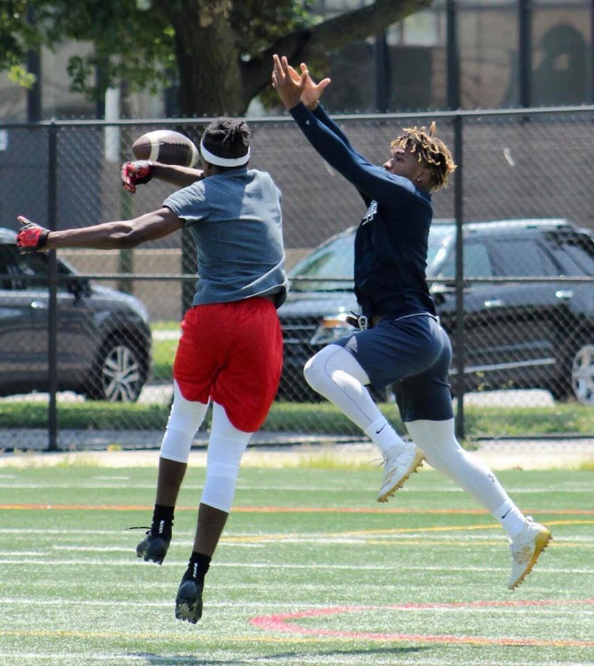 Two men are playing a game of football on a field