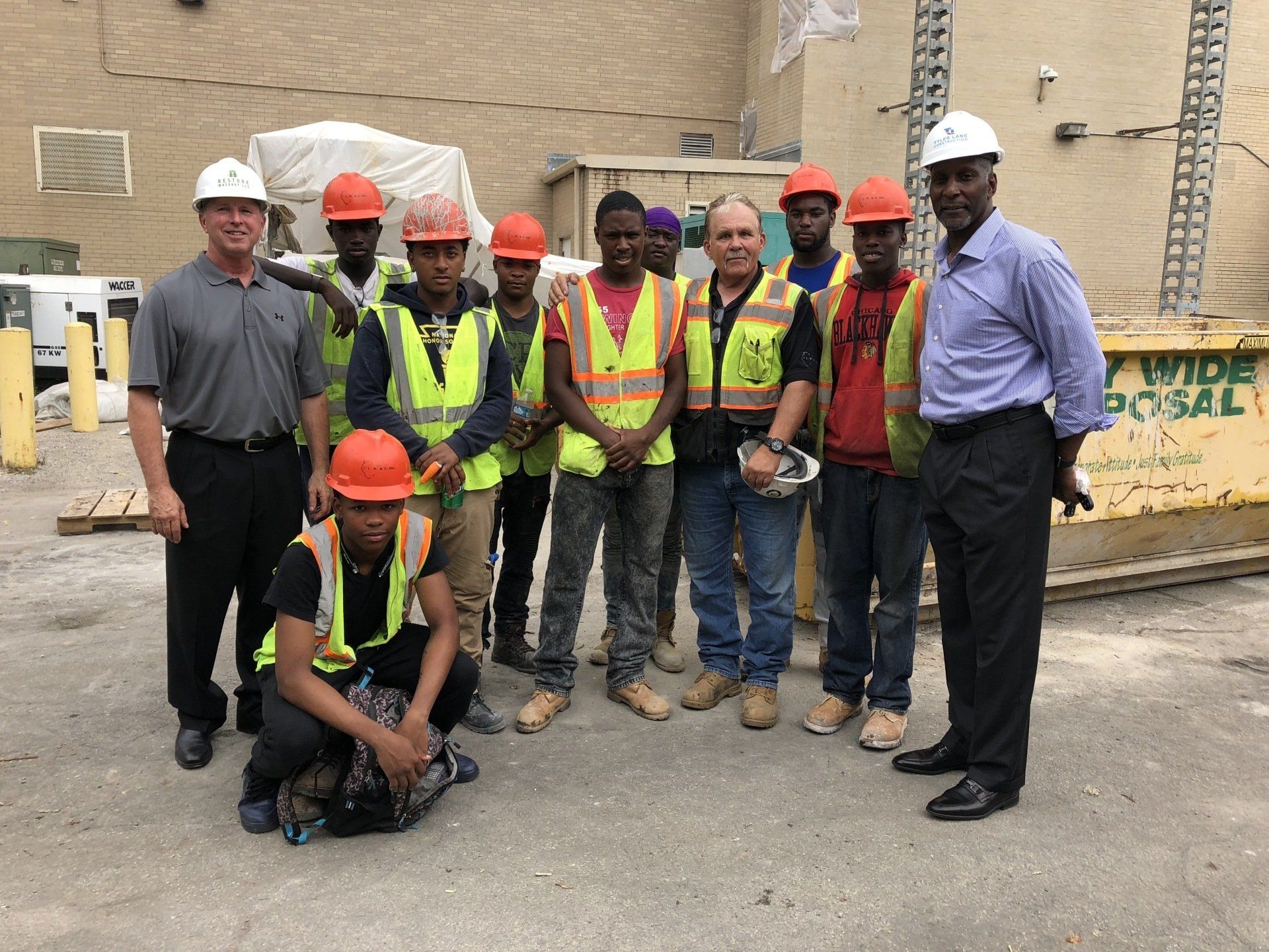 A group of construction workers are posing for a picture.