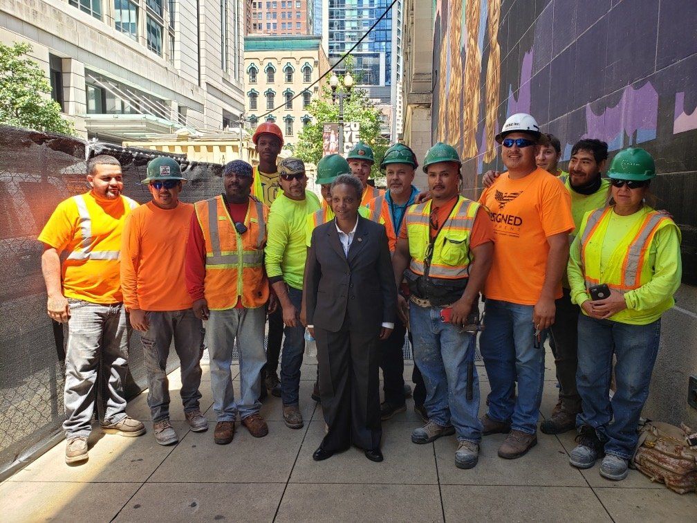 A group of construction workers are posing for a picture.