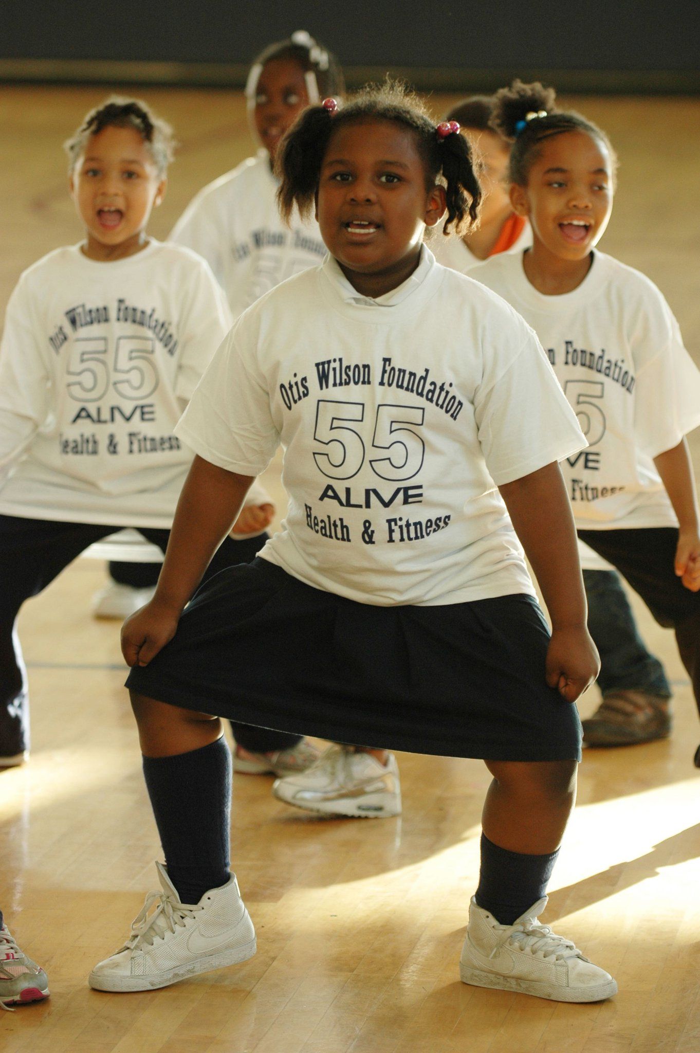 A group of young girls wearing shirts that say 55 alive