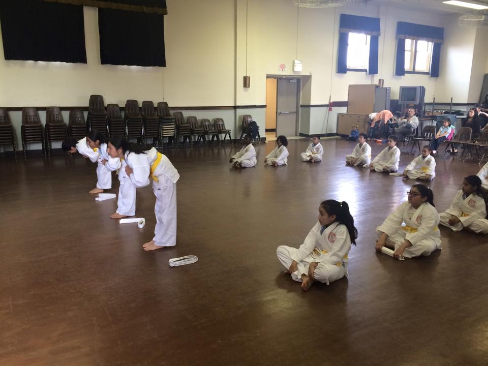 A group of children are practicing martial arts in a gym