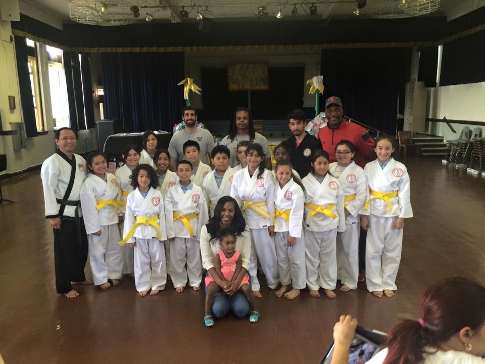 A group of children in karate uniforms pose for a picture