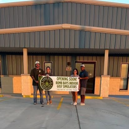 People holding a banner outside a building that says