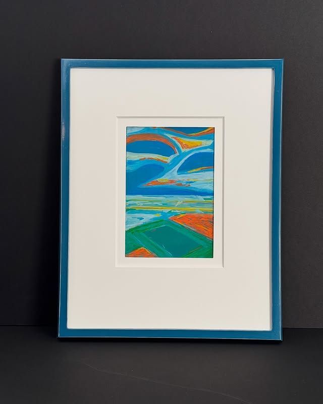A small landscape painting in a blue frame featuring abstract green and orange fields under a stylized, swirling sky.