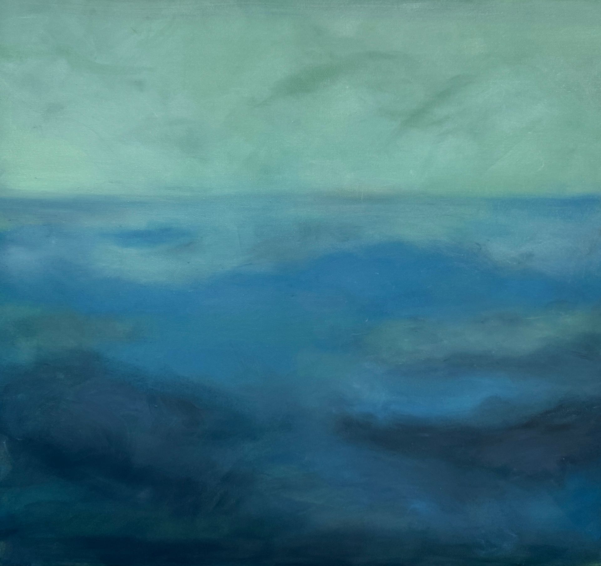 Abstract blue and green seascape with a hazy horizon and dark water below