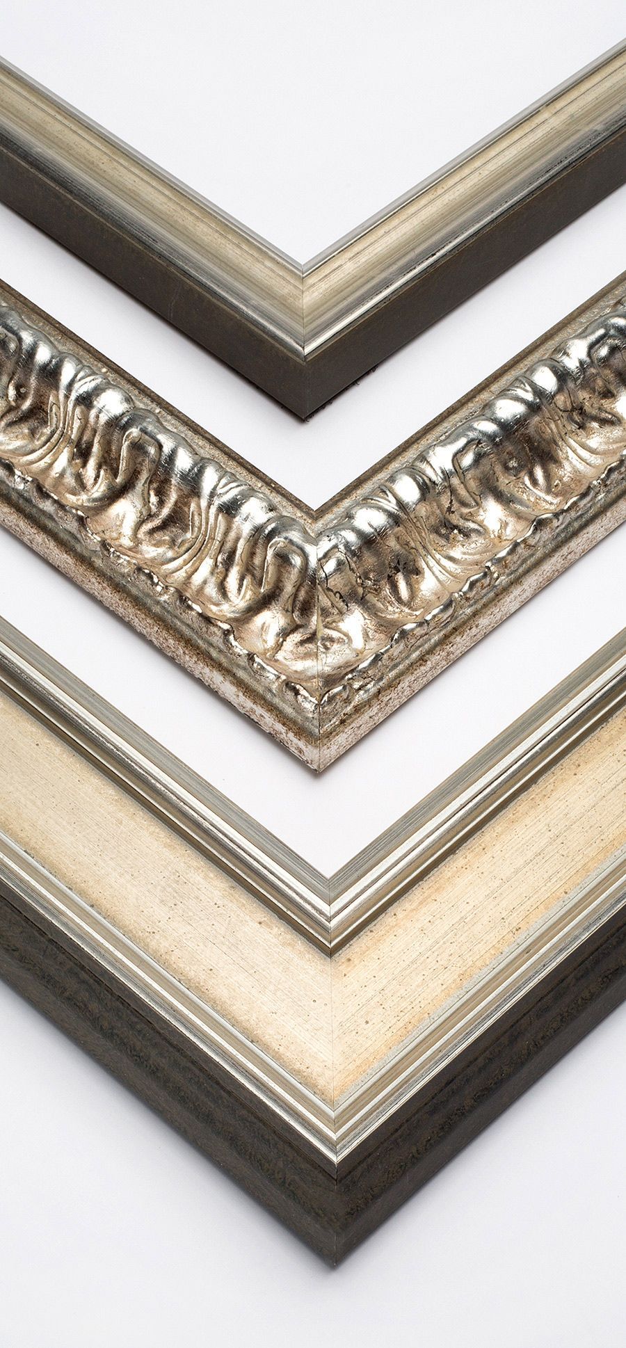 Three stacked samples of ornate decorative picture frame molding with metallic gold and silver finishes.