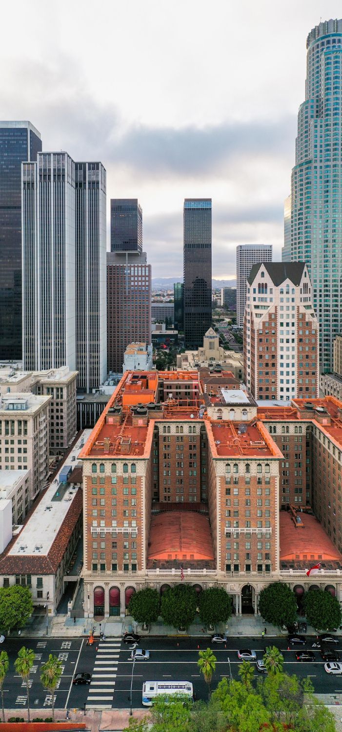 Downtown Los Angeles cityscape featuring a mix of modern and historic buildings under a cloudy sky.