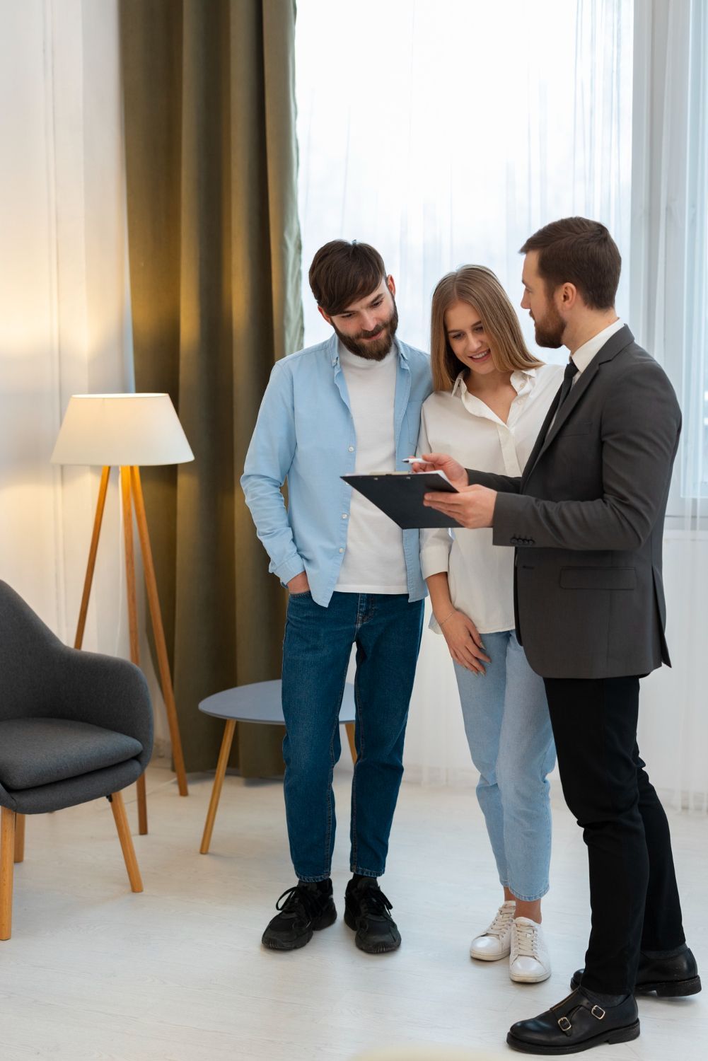 A real estate agent showing a document to a couple in a bright, modern room.
