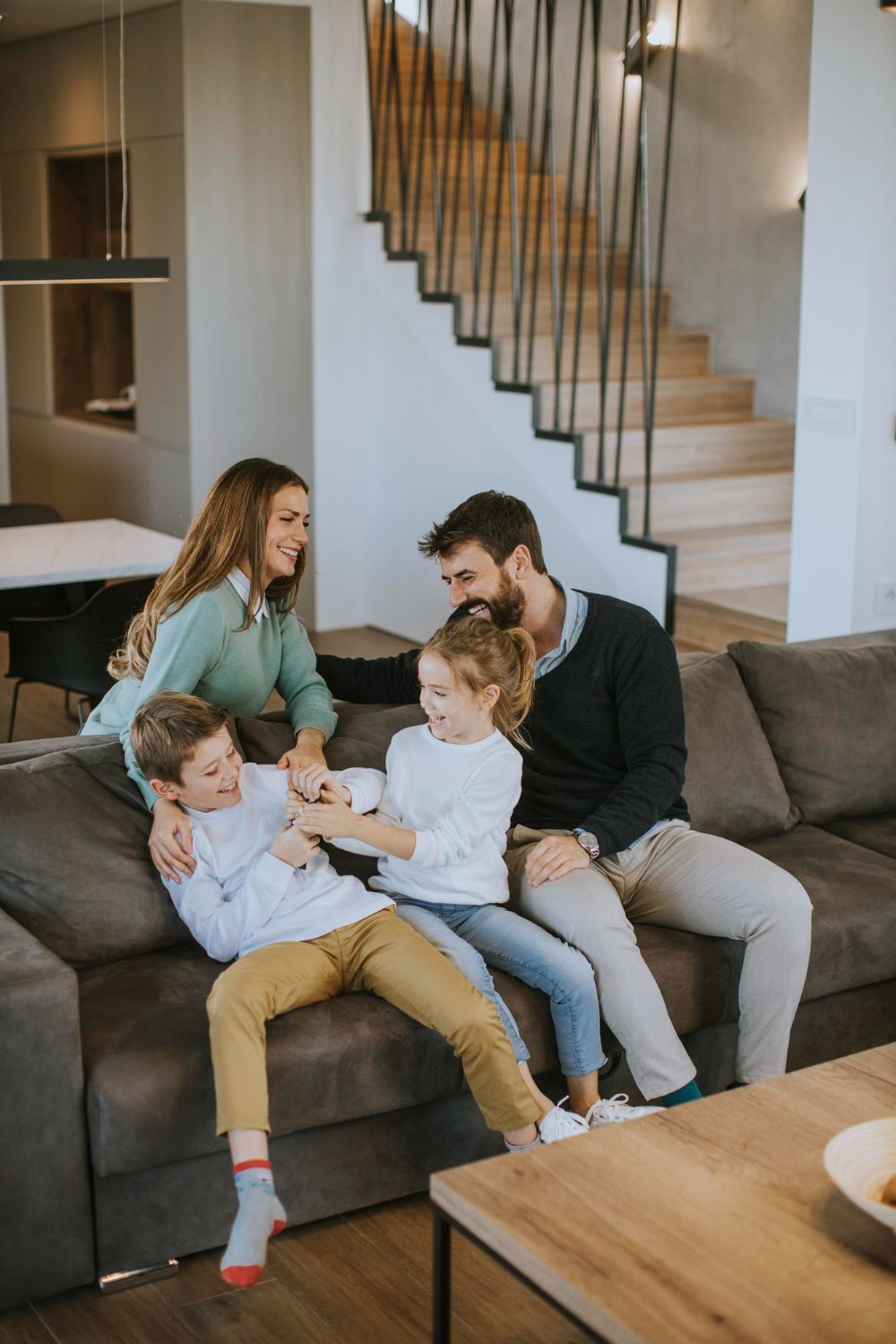 Family sitting on a couch, interacting in a modern living room.