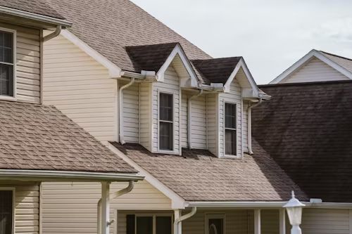 A house with a brown roof and white siding