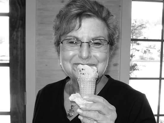 A woman is eating an ice cream cone in a black and white photo.