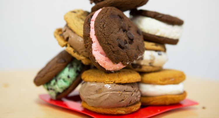 A stack of ice cream sandwiches on a red plate on a table.