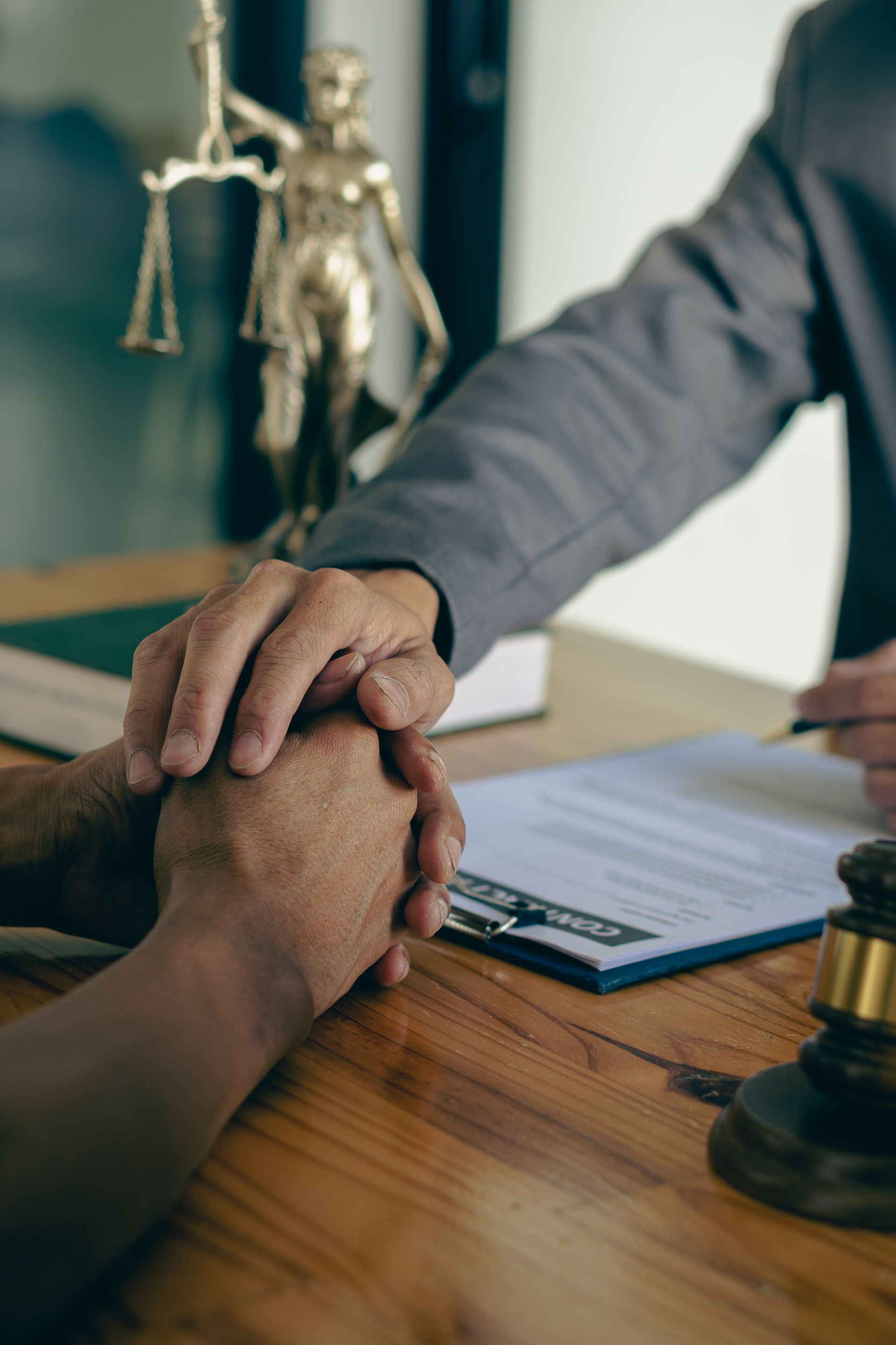 Attorney-consultants hand in hand to offer comforting advice to clients after consulting and providing details about the lawsuit. and defend the case that has been fully accepted lawyer concept.