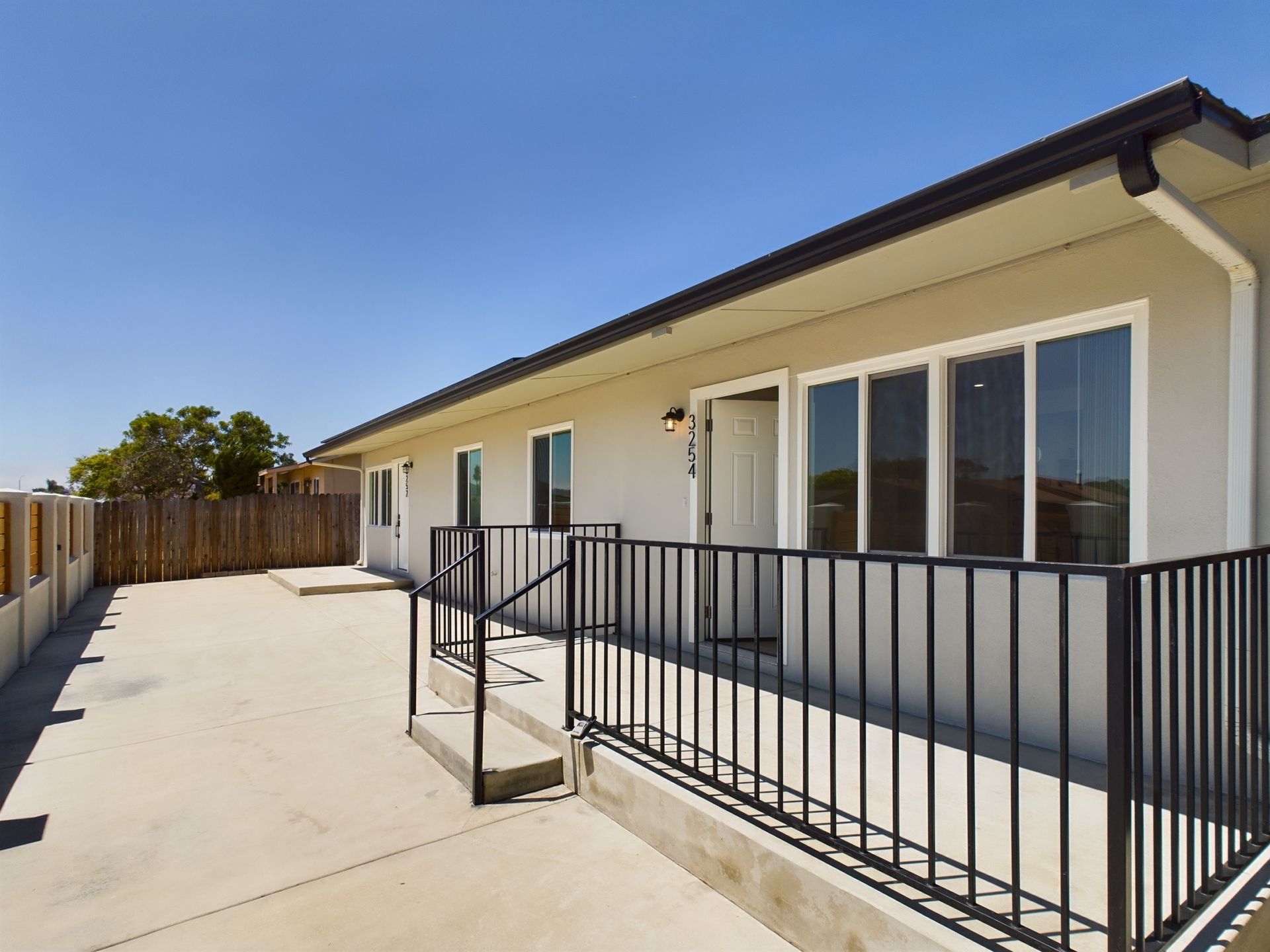 A white house with a black railing and stairs