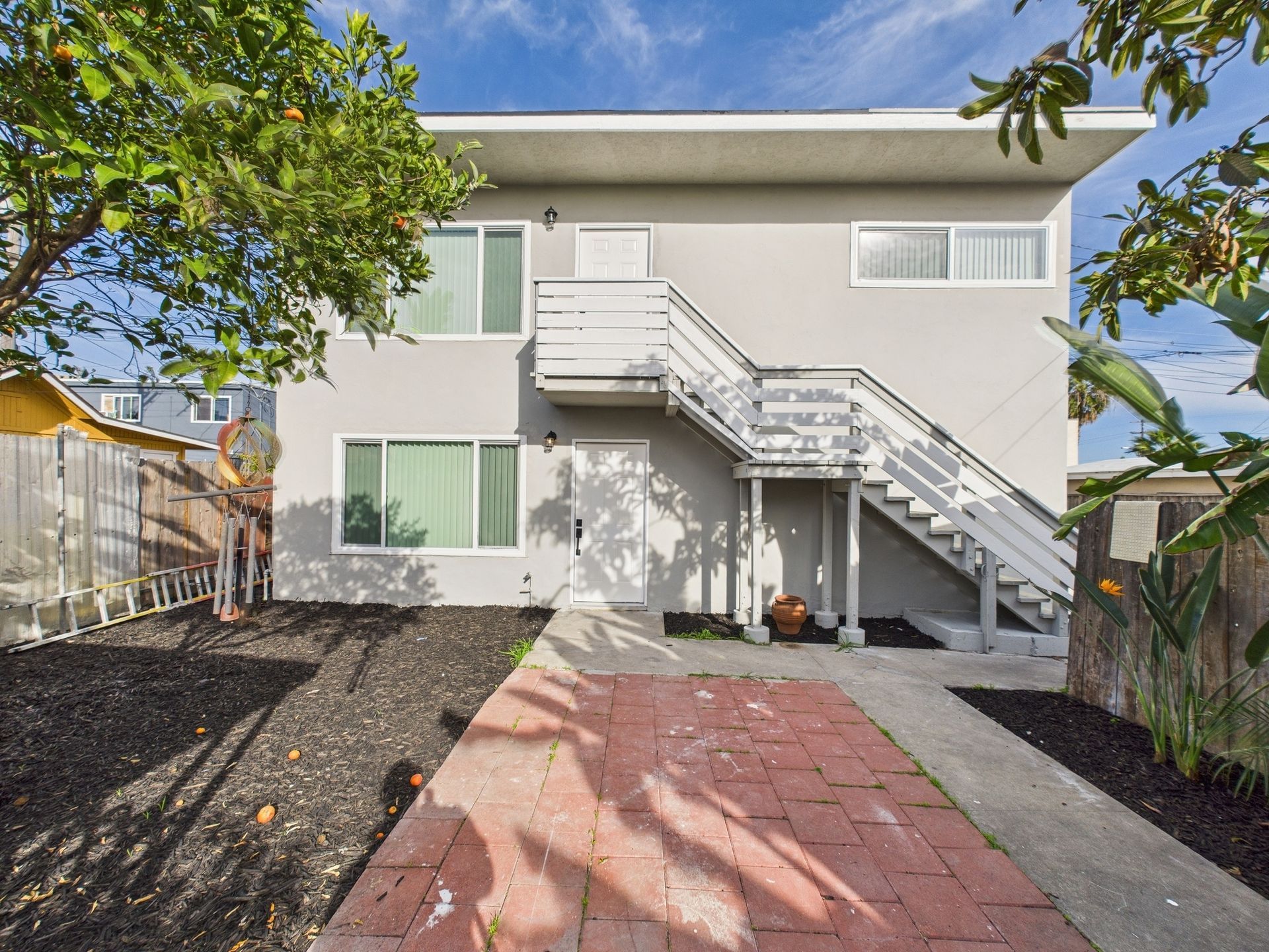 A white house with stairs leading up to the second floor