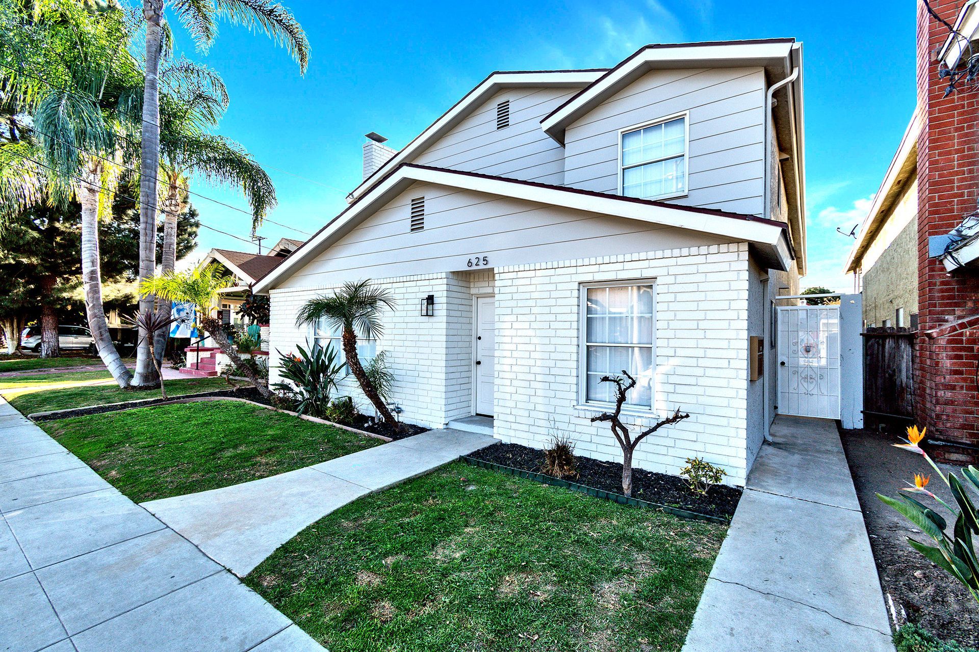 A white house with a palm tree in front of it