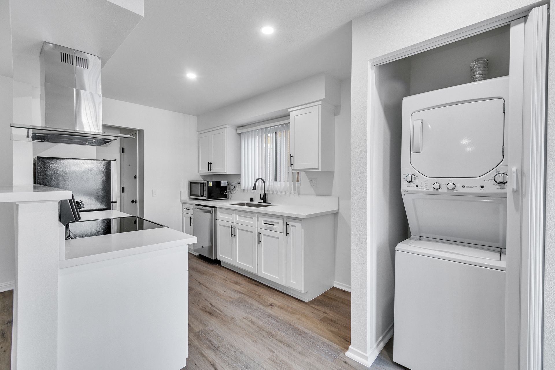 A kitchen with a washer and dryer stacked on top of each other.