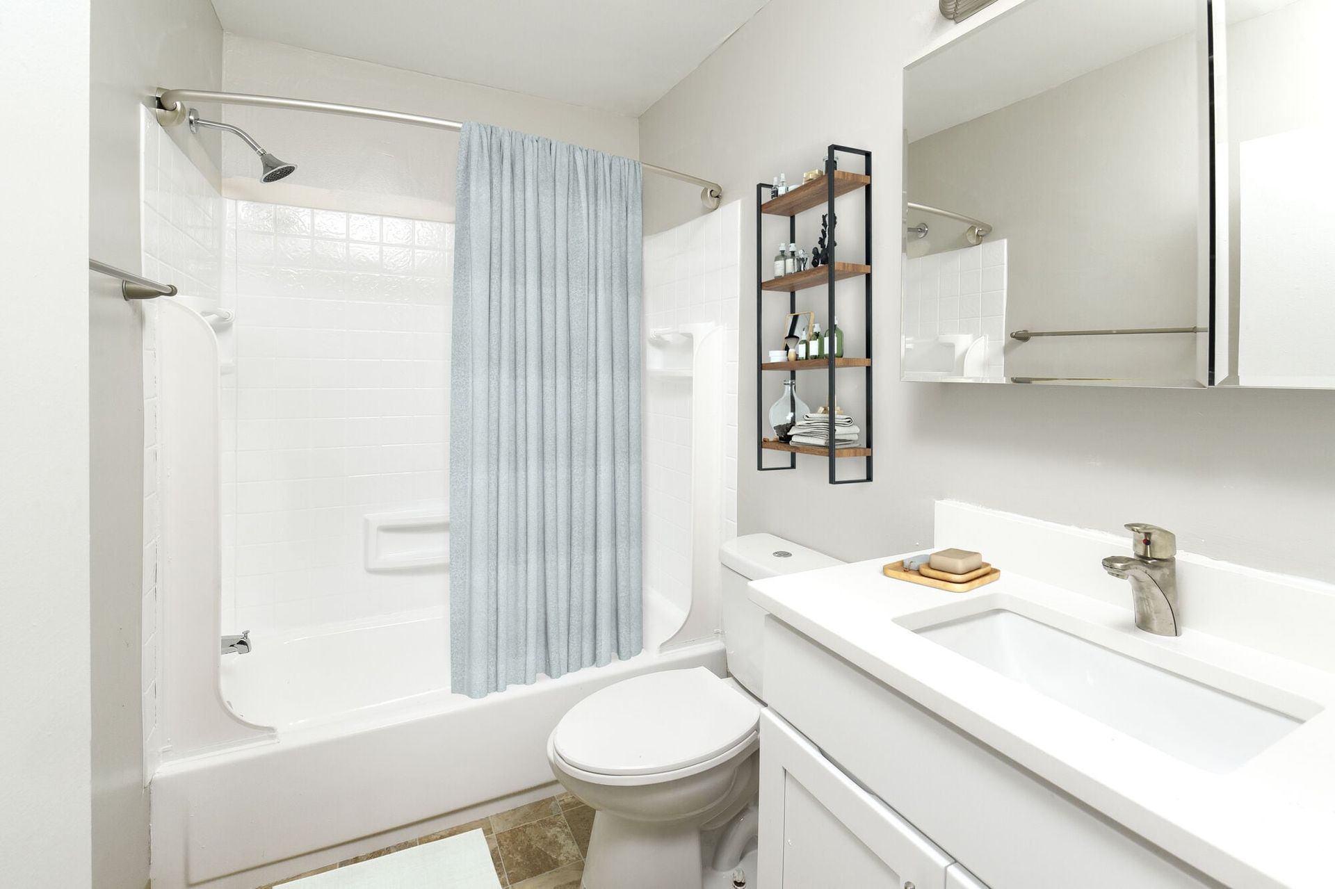 Bright apartment bathroom with tub/shower, light-gray curtain, toilet, and white vanity.