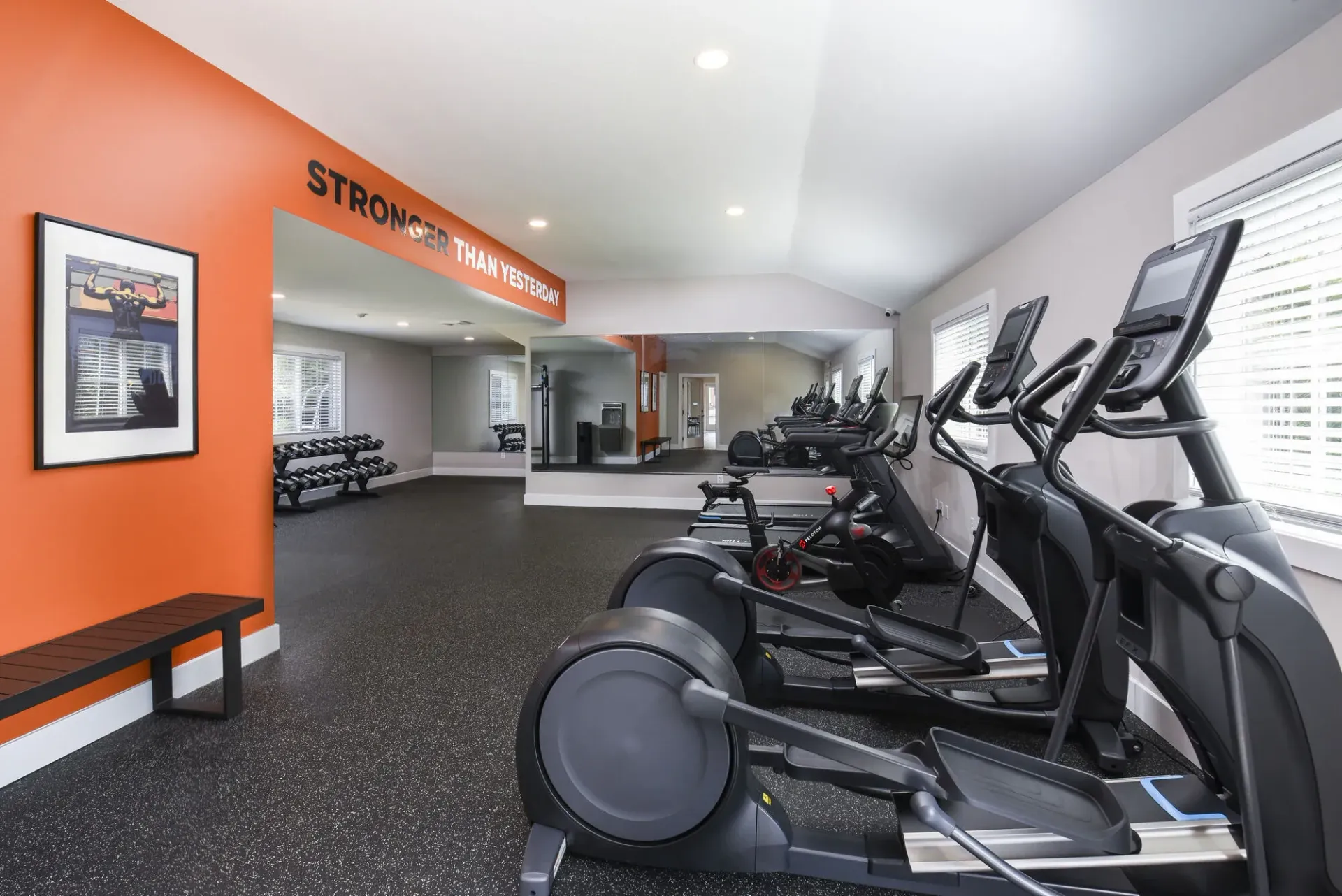 Fitness center with cardio machines and mirrors.