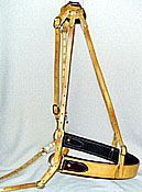 A light-colored leather horse breast collar with straps, buckles, and a padded black center.