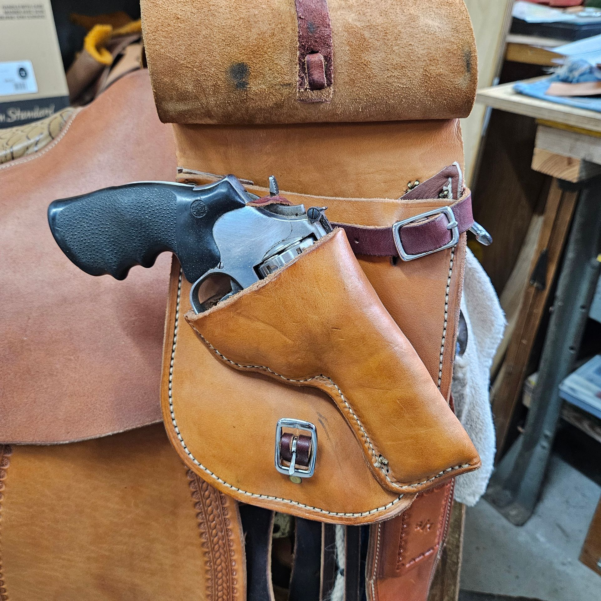 Leather saddle bag with a revolver in a holster attached to the side.