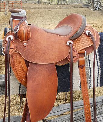 Leather western saddle on a rack, brown tones.