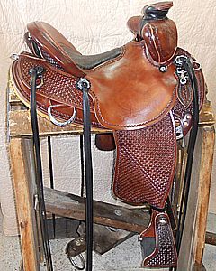 Brown leather Western horse saddle on a wooden rack, with basket weave pattern on the fenders.