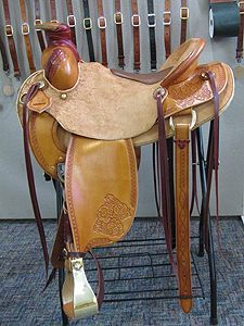 Tan and brown leather western saddle on display.