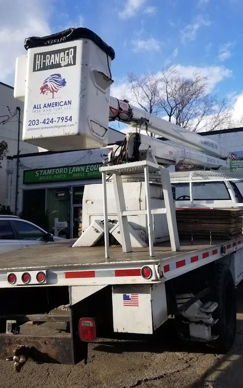Bucket truck with raised platform in front of a building.
