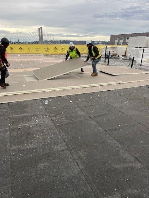 A group of construction workers are working on a roof