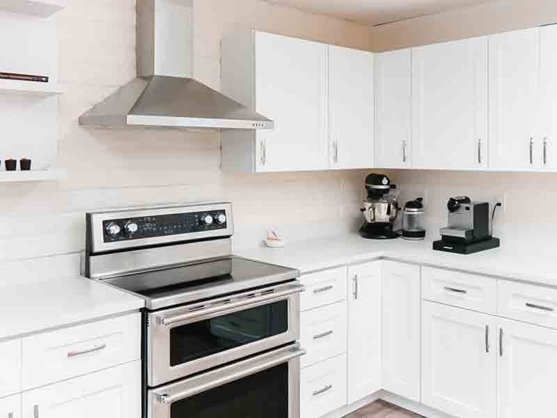 A kitchen with stainless steel appliances and white cabinets.