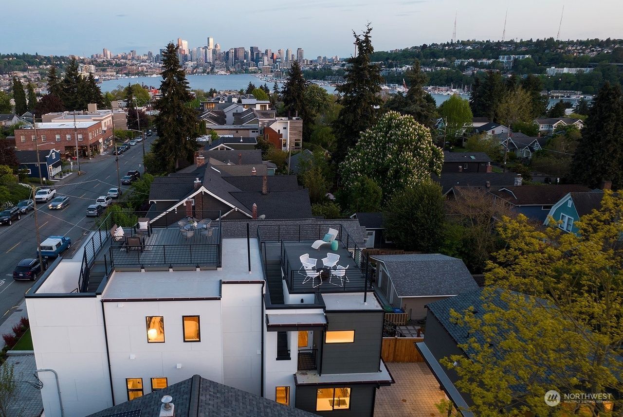An aerial view of a house with a city in the background
