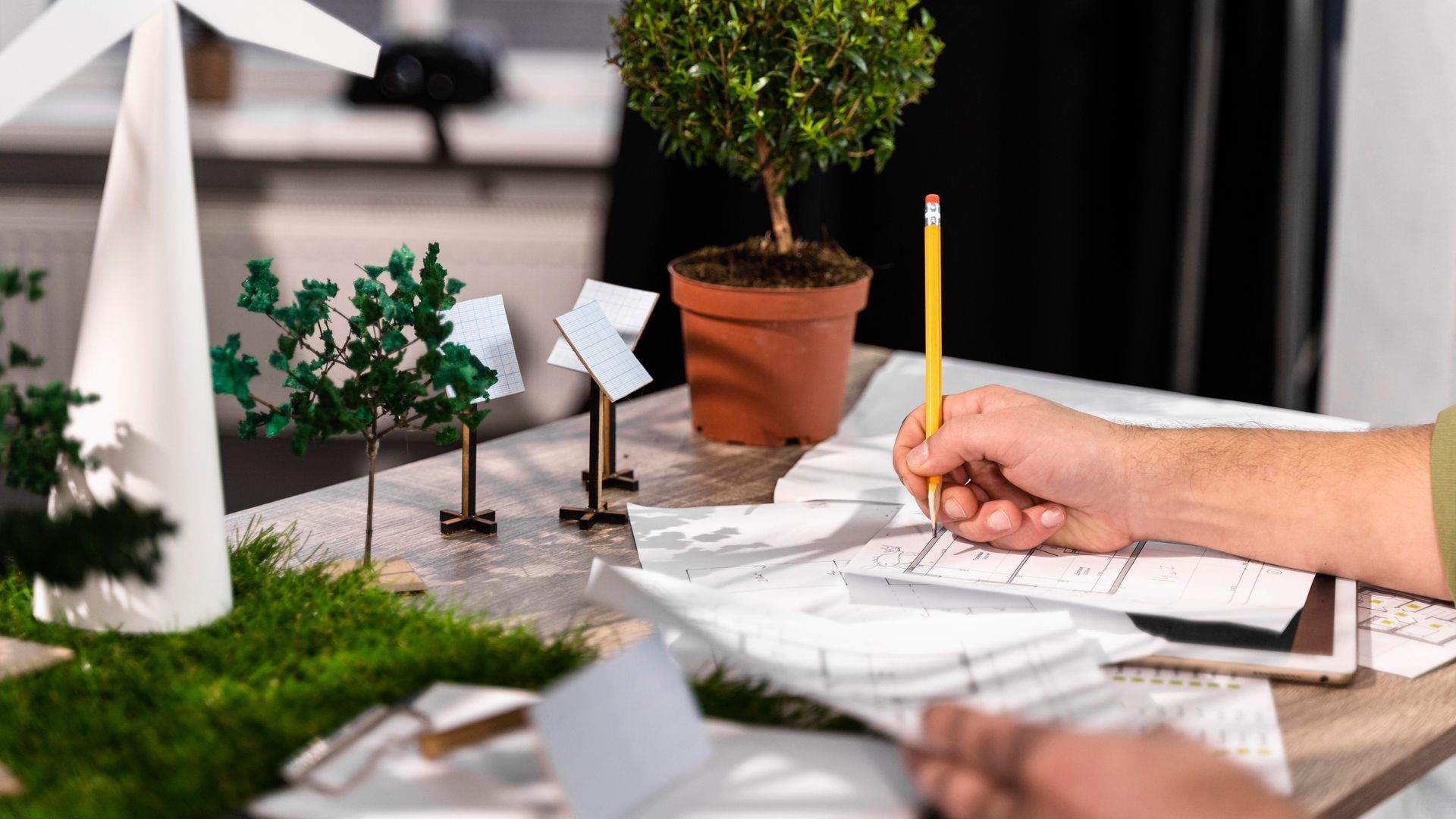A person is sitting at a table with a pencil in their hand.