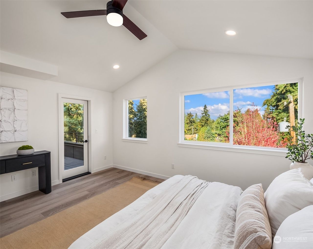 A bedroom with a large bed and a ceiling fan.