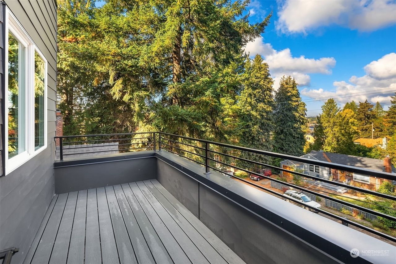 A balcony with a view of trees and a city