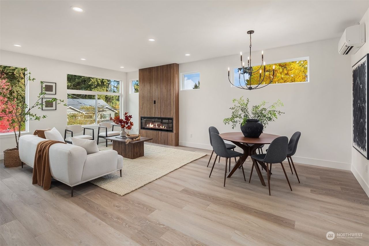 A living room with a couch , table and chairs and a fireplace.