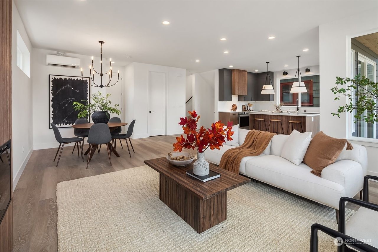 A living room with a white couch and a wooden coffee table.