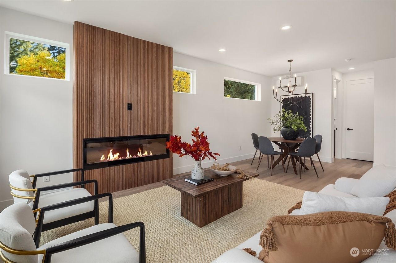 A living room with a fireplace , couch , chairs and a coffee table.