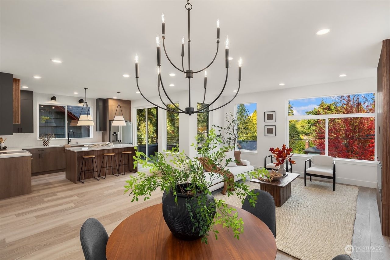A living room with a table and chairs and a chandelier hanging from the ceiling.