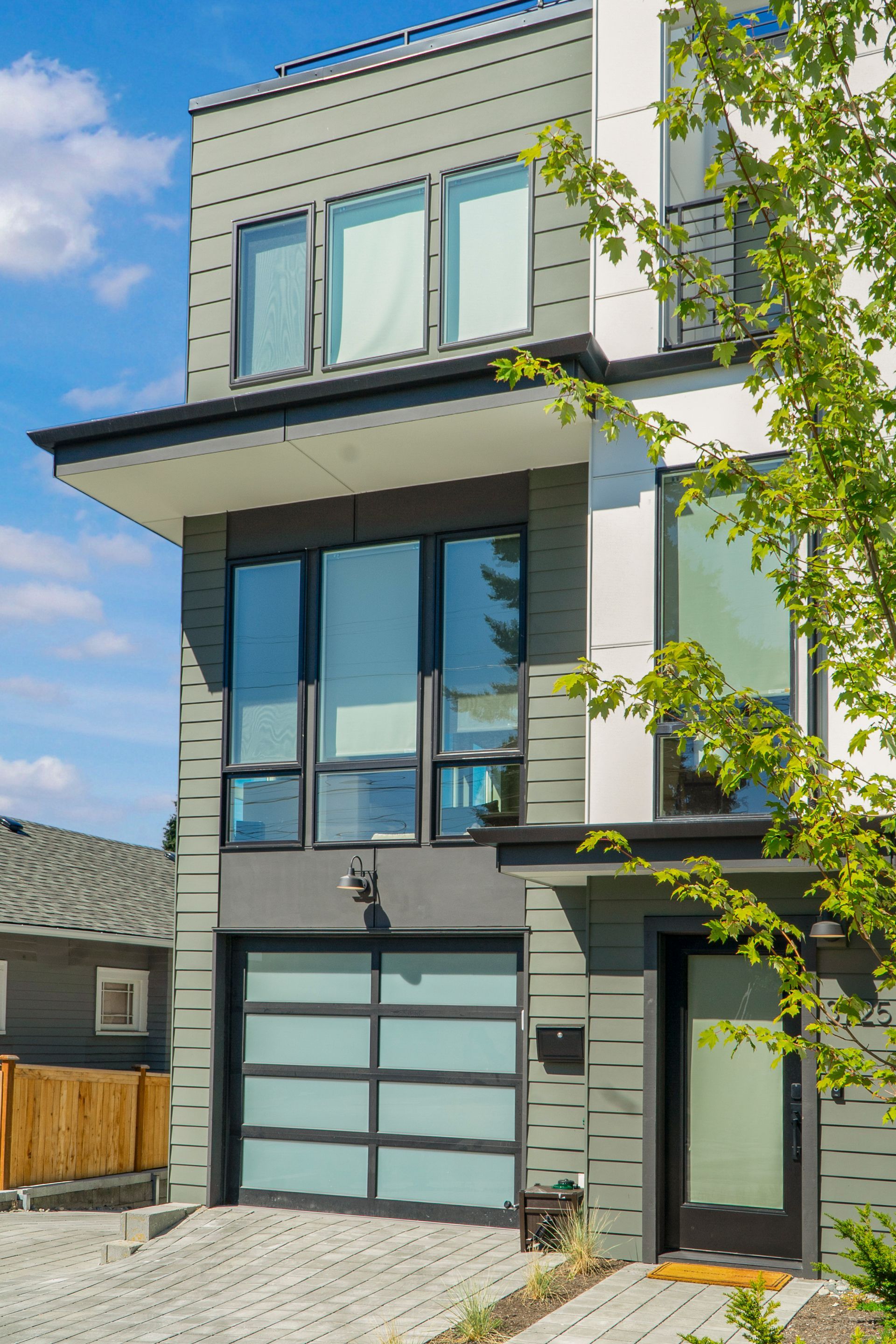 A modern house with a large garage door and lots of windows.