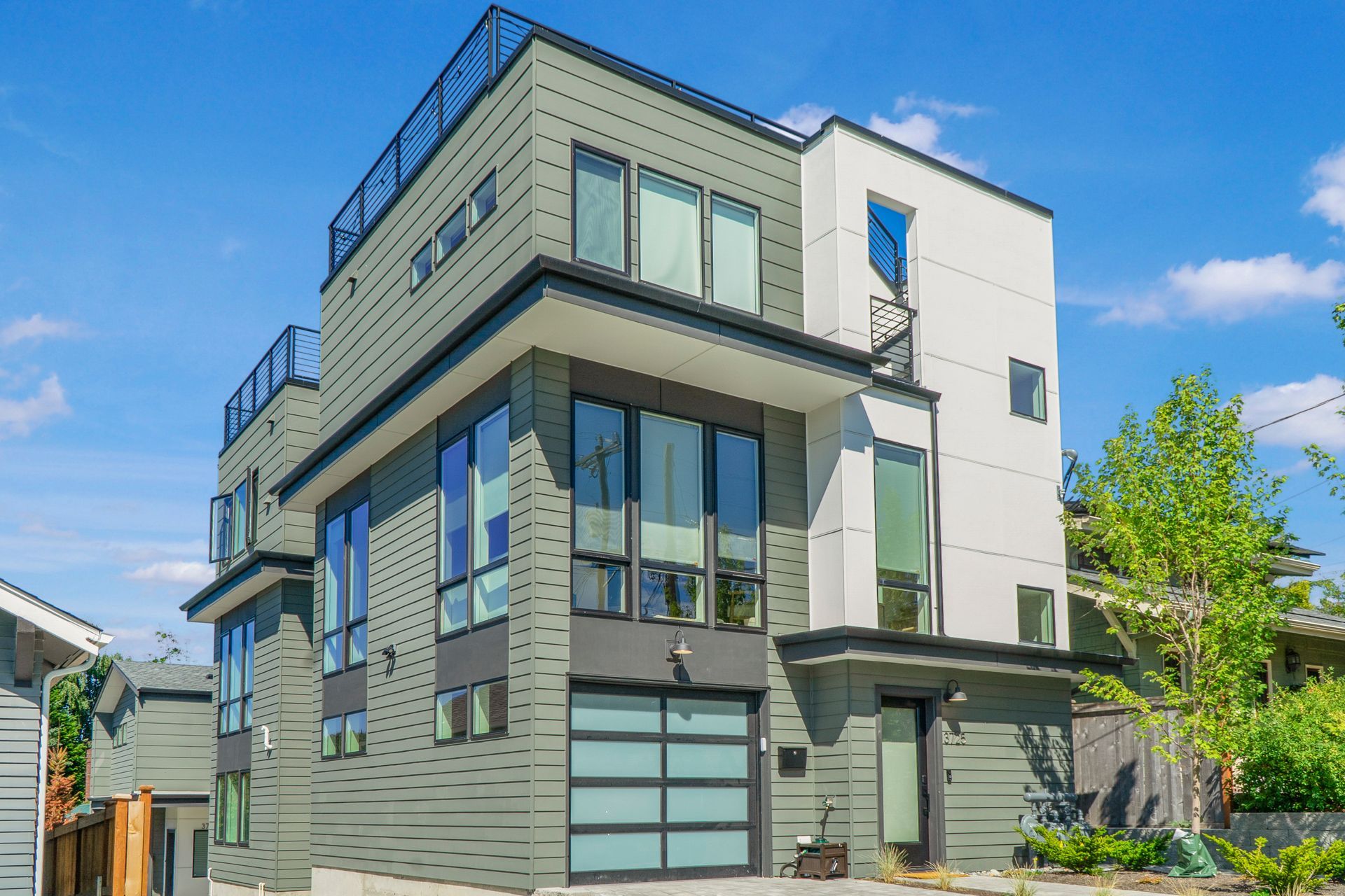 A large modern house with a lot of windows and a garage door.