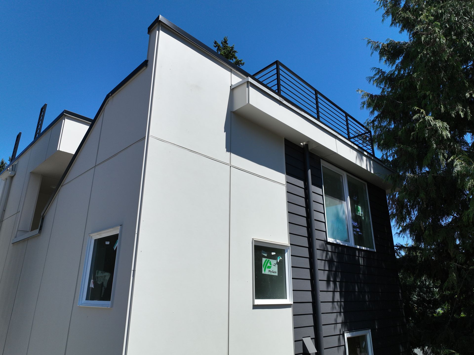 A white and black house with a balcony on top