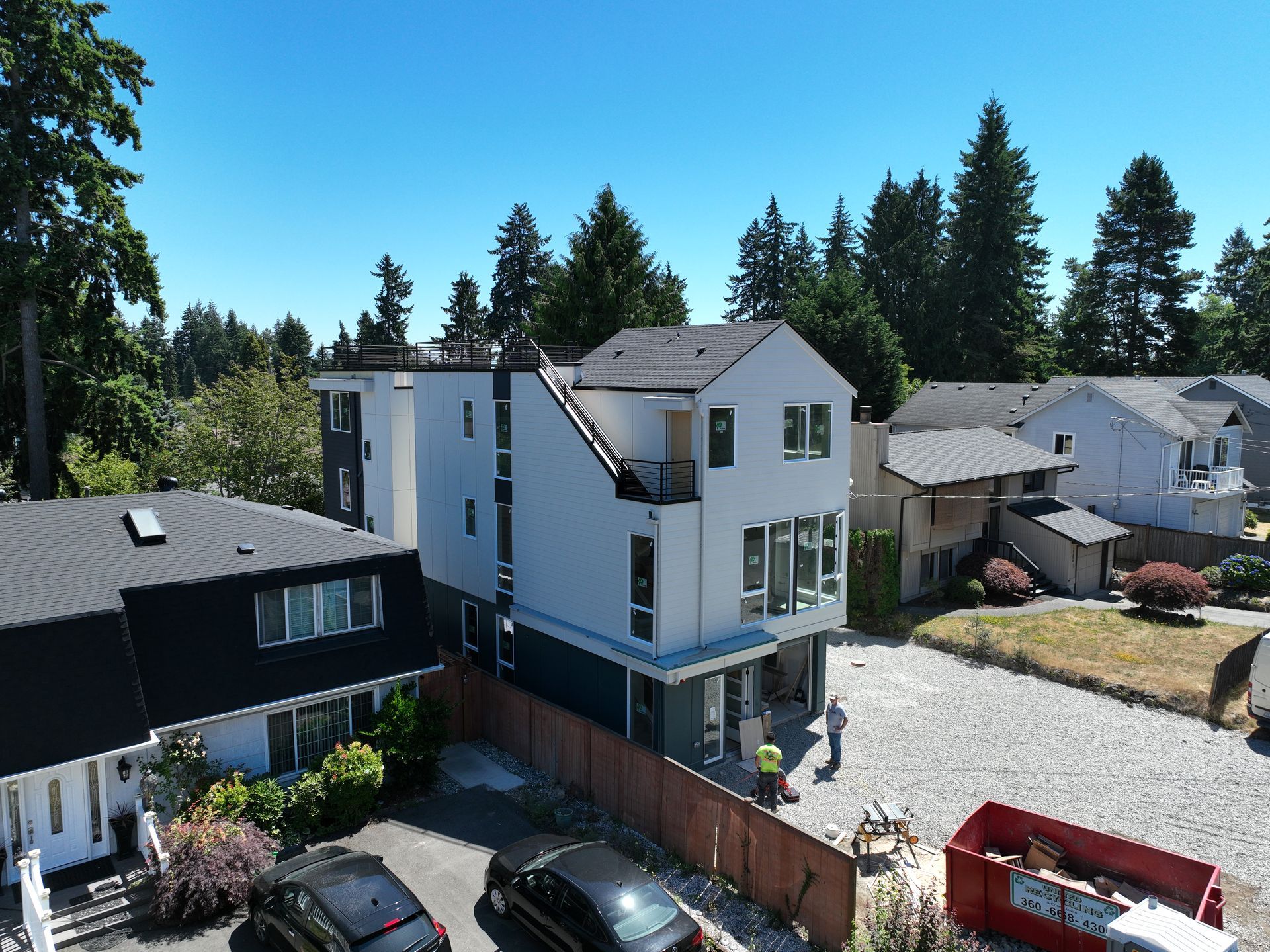 An aerial view of a house with cars parked in front of it